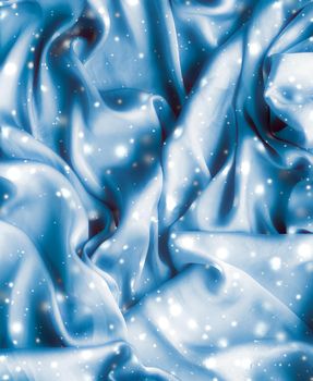 Winter fashion, shiny fabric and glamour style concept - Magic holiday blue soft silk flatlay background texture with glowing snow, luxury beauty abstract backdrop