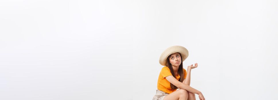 Lifestyle and travel Concept: Young beautiful caucasian woman is sitting on suitecase and waiting for her flight.Isolated over white background.