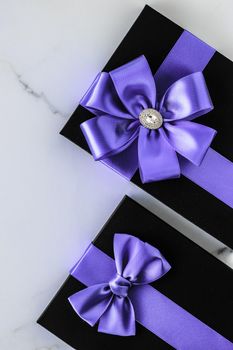 Wedding present, shop sale promotion and anniversary celebration concept - Luxury holiday gifts with lavender silk ribbon and bow on marble background