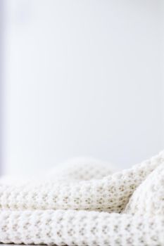 Knitwear, fabric textures and handmade items concept - Warm knitted clothes, soft and white