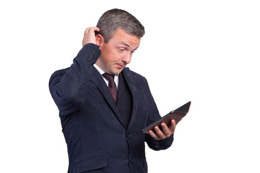 A handsome man learns news on the Internet and, puzzled, takes his head. Man on a white isolated background.