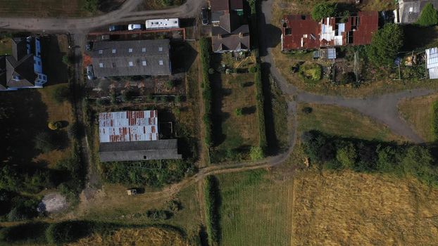 Top Down Aerial View of Green and Yellow Wheat Field Farm and Greenhouses. Golden Crops During Pasture Aerial View. Agricultural Work in Summer During Drought. Grain Crisis. Nature, Harvesting, Eco