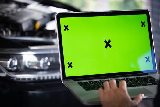Interactive diagnostics software on an advanced computer. Car service mechanic uses laptop computer with green screen mock up chroma key car diagnostic software. Automotive electronic diagnostic app.