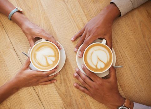 Creative latte art, cappuccino and coffee drink in cafe with couple and friends enjoying cup of java with milk froth together. Closeup of people hands from above meeting and drinking in restaurant.