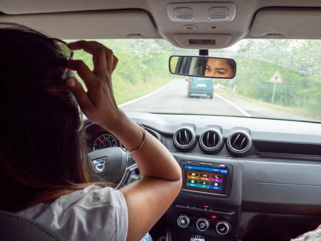 Beautiful business lady driving her car a cloudy day in summertime