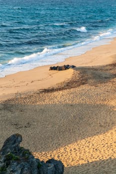 Deserted sandy beach of the atlantic ocean in the rays of the setting sun top view