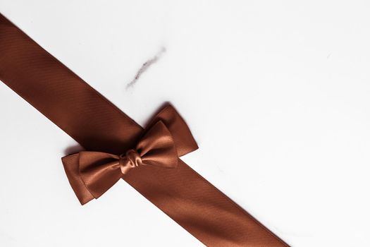 Holiday gift, decoration and sale promotion concept - Chocolate brown silk ribbon on marble background, flatlay