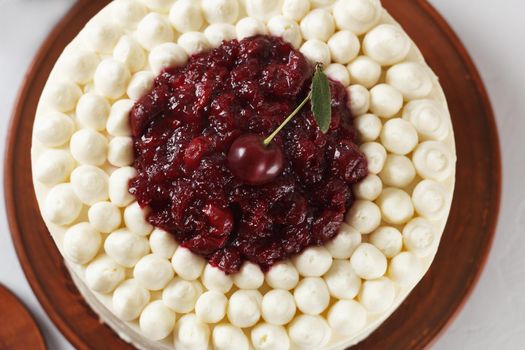 Biscuit cake, cherry souffl with cream cheese and cherry confiture on a gray background. close-up