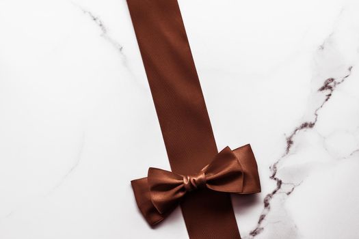 Holiday gift, decoration and sale promotion concept - Chocolate brown silk ribbon on marble background, flatlay