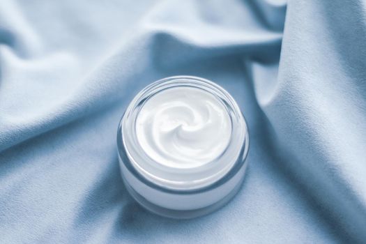 Beauty, anti-age cosmetics and skincare concept - Luxury face cream jar on blue silk