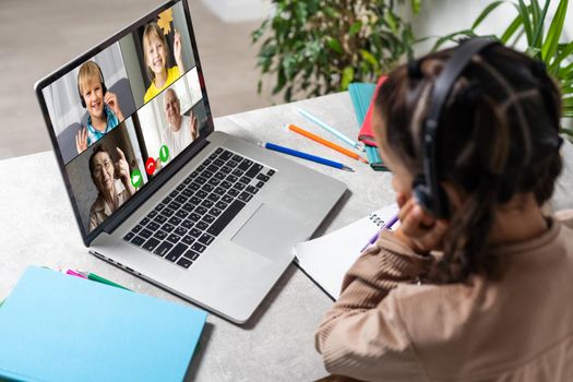 E-Learning. Shocked Little Schoolgirl Looking At Laptop Wearing Headphones Looking At Computer Web Camera In Shock Making Video Call And Learning Online At Home. Shocking News Concept