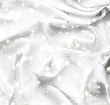 Winter fashion, shiny fabric and glamour style concept - Magic holiday white soft silk flatlay background texture with glowing snow, luxury beauty abstract backdrop