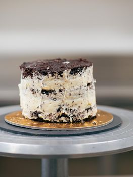 professional baker decorating a chocolate and cream cake with salty caramel