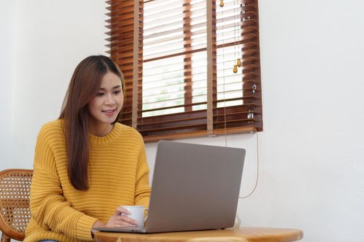 Portrait of an Asian businesswoman or business owner taking a coffee break while working in the office.