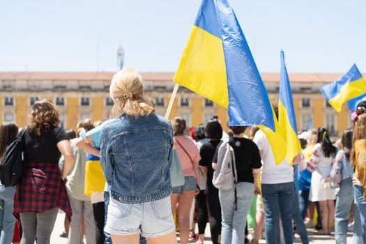 Portugal, Lisbon April 2022: The demonstration on Commerce Square in support of Ukraine and against the Russian aggression. Protesters against Russia's war Many people with Ukrainian flags. Crowd