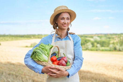 Woman farmer straw hat holding basket vegetable onion tomato salad cucumber standing farmland smiling Female agronomist specialist farming agribusiness Happy Girl dressed apron cultivated wheat field