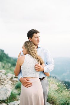 Man hugging a woman high in the mountains. High quality photo