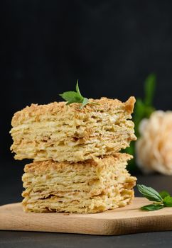 A stack of baked Napoleon pie slices with cream. Puff pastry, delicious dessert