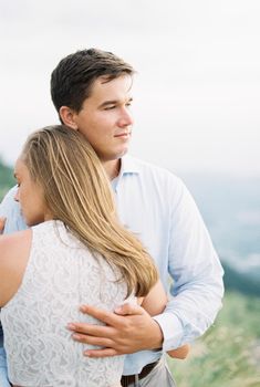 Man hugging a woman in the mountains. Portrait. High quality photo