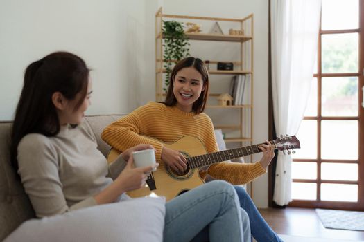 A beginner woman with best friend playing acoustic guitar lesson.