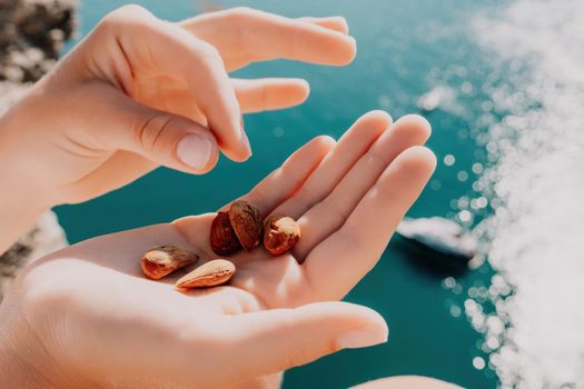 Unrecognizable caucasian woman eating young milky almond nuts. Healthy vegan food