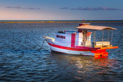 Idyllic Porto Seguro Beach at sunset with fishing trawler in BAHIA, Northeastern Brazil