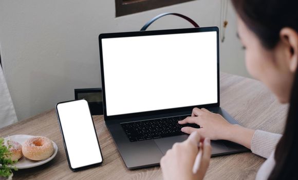 computer screen,cell phone blank mockup.hand woman work using laptop texting mobile.with white background for advertising,contact business search information on desk in cafe.marketing,design.