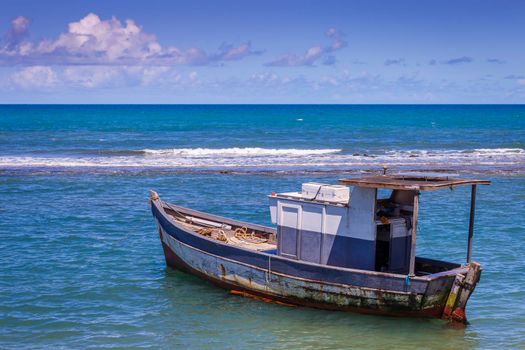 Idyllic Porto Seguro Beach at sunset with fishing trawler in BAHIA, Northeastern Brazil