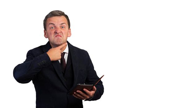 A disgruntled man in a jacket with a tie and a white shirt puts his finger to his throat on a white isolated background.