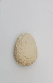 Artificial not natural egg coating with plaster, primer on a white paper background.