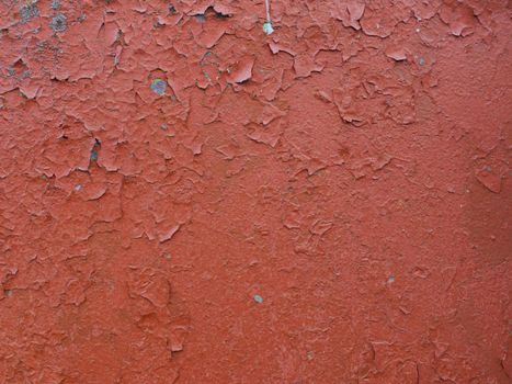 Old peeling red paint on an old wall. red paint texture on wall background.