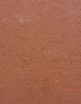 Peeling brown plaster on the wall. Abstract background for design.