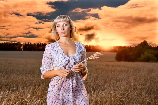 beautiful woman walking on wheat field before sunset
