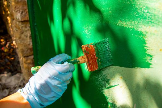 a man's hand paints the wall with paint.