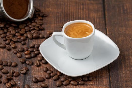 Fresh espresso coffee together decorated with coffee beans on wooden table