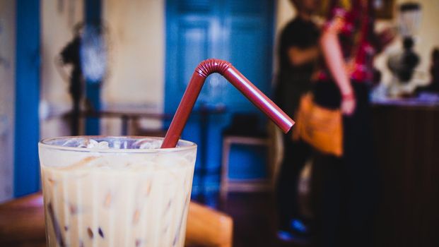 iced latte coffee in a glass with cream on bottom . cold summer drink background