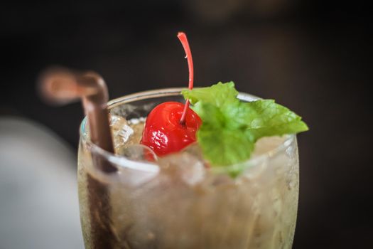 Fresh summer drink mocktail beverage pour in glass cherry and mint leaf decoration on top.