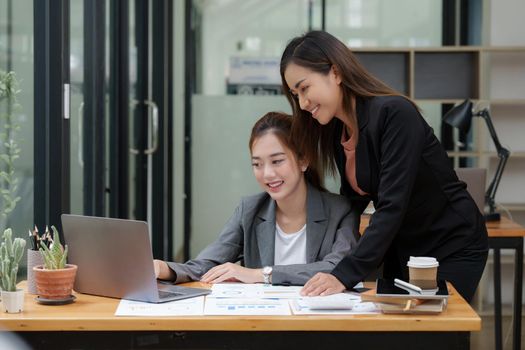 Two Asian Business woman working together by laptop at office.
