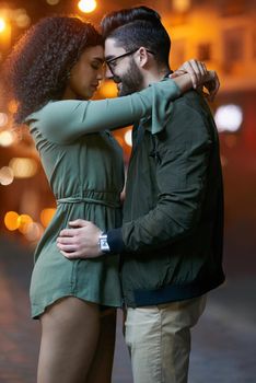 Lost in love. a happy young couple embracing outdoors at night