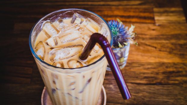 iced latte coffee in a glass with cream on bottom . cold summer drink background
