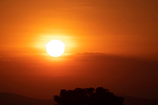 Beautiful sun at sunset sky above clouds orange sunset sky. Beautiful sky. Dramatic red yellow sunset over the forest