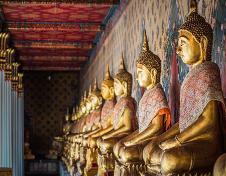 Row of brass gold Buddha statue image in meditation posture