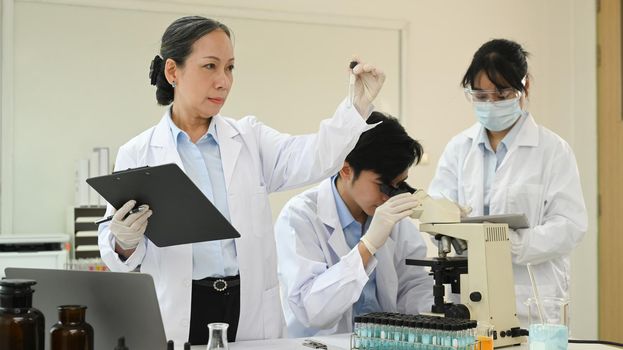 Biotechnology specialist team conducting experiment in a laboratory. Concepts of medicine and science researching.