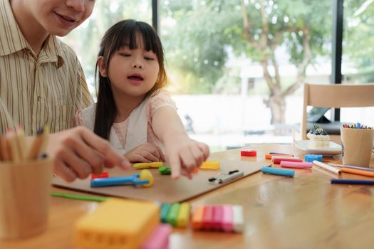 Adorable little girl and father playing with colorful plasticine. Handmade skills training.