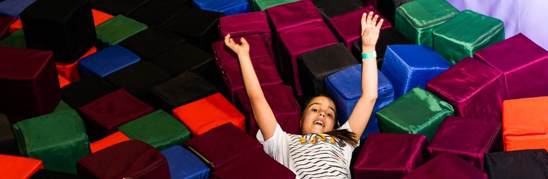 Little pretty smiling girl lying on the trampoline.