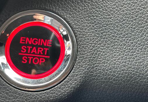 car engine start stop button on dark leather background. copy space Engine Start Button on my car