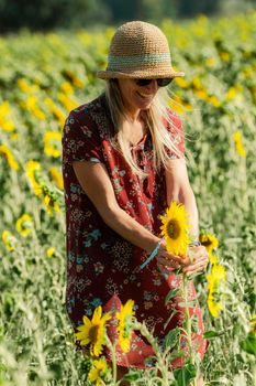 Woman among the sunflowers receive the beautiful afternoon sun.