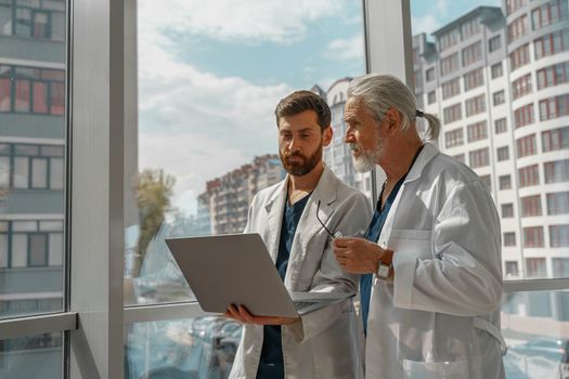 Two doctors are looking at something on the laptop in the doctor's office. High quality photo