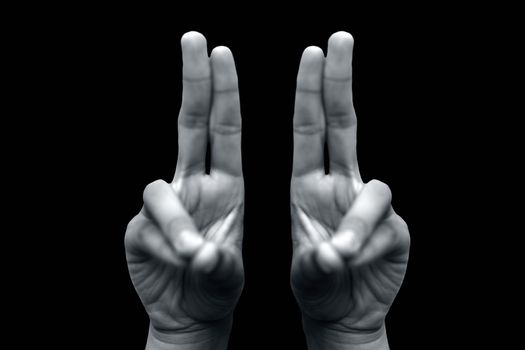 Isolated pair of male hands demonstrating Kapitthaka Mudra isolated on a black colored background. Vertical shot of Kapitthaka Yoga Mudra.
