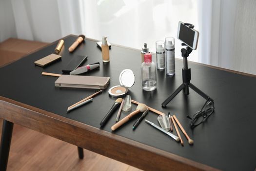 Cosmetics and makeup brushes on the desk of blogger